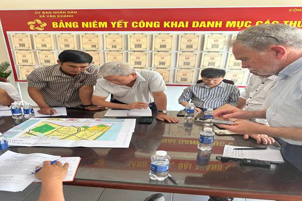 Doan cong tac xem ban do tai UBND xa Van Khanh